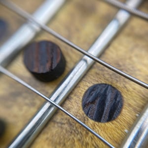 Incrustación de trastes oscuros y puntos laterales de madera de wengué