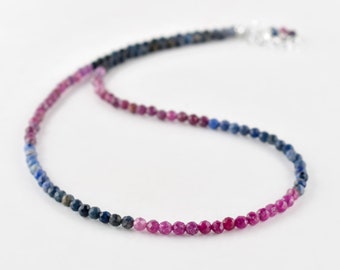 May include: A delicate necklace made with small, faceted sapphire beads. The beads are a gradient of blue and pink, creating a beautiful ombre effect.