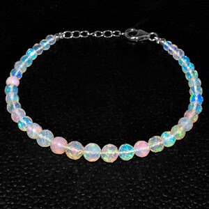 May include: A delicate bracelet made with iridescent white opal beads and a silver clasp.