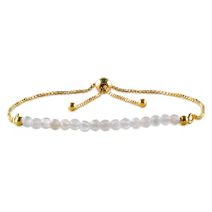 May include: A gold-toned adjustable bracelet featuring a row of small, light pink beads. The bracelet has a delicate chain and a sliding bead closure for adjusting the size. The beads are evenly spaced.