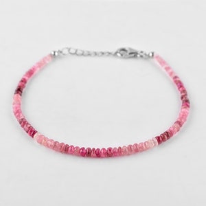 Peut inclure: Un bracelet délicat en tourmaline rose avec un fermoir argenté. Le bracelet est composé de petites perles rondes de tailles différentes, créant un effet ombré subtil.