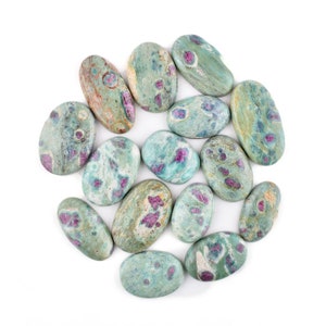 May include: A collection of oval-shaped green and pink stones with a speckled pattern. The stones are arranged in a circle on a white background.