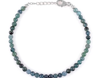 May include: A silver chain bracelet with a silver clasp and blue gemstone beads. The beads are faceted and range in color from light blue to dark green.
