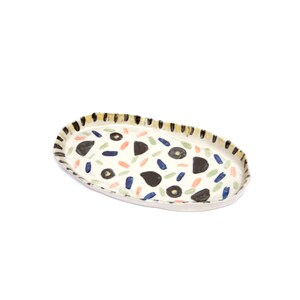 May include: White oval ceramic serving tray with a black, yellow, blue, green, and orange abstract pattern.