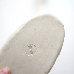 May include: White ceramic oval dish with a stamped mark on the bottom that reads "Miriam".