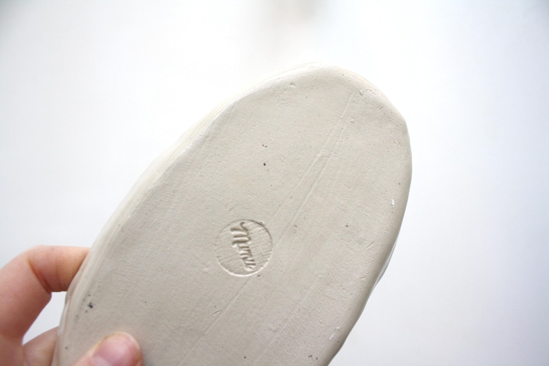 May include: White ceramic oval dish with a stamped mark on the bottom that reads "Miriam".