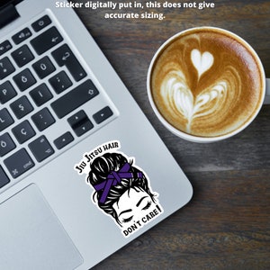 Może przedstawiać: Naklejka z kresk&oacute;wkową ilustracją kobiety z kokiem. Kok jest związany purpurową wstążką. Tekst "Jiu Jitsu Hair Don't Care!" jest napisany pod ilustracją.