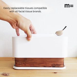 May include: White tissue box holder with a wooden base and a small bird figurine on top. The box is labeled "Cellox" and the holder is labeled "m=".