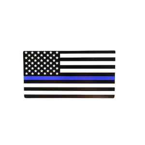 May include: A rectangular sticker featuring a stylized American flag design. The flag has a black and white color scheme with a blue stripe, and a field of white stars on a black background.