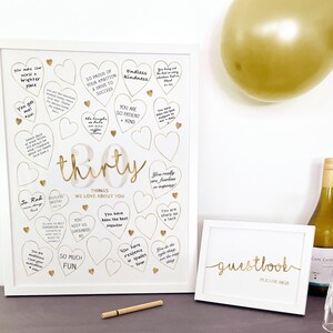 30th Birthday Sign made as a digital printable download for 30th Birthday Decoration to match Gold Party Supplies. Displayed on a black table in two white picture frames, with pen for Guests to write their heartfelt nostalgics messages for the 50 Year Old Woman.
