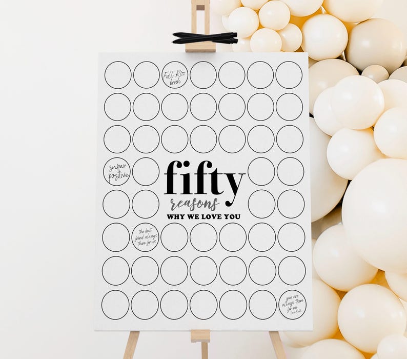 May include: A white sign on a wooden easel with the text "fifty reasons why we love you" in black. The sign has 50 blank circles for writing reasons. A cluster of white balloons is in the background.
