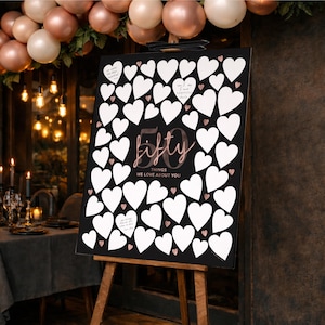 Moody 50th Birthday sign for women turning 50, on display on an easel at the entrance to the party, with 50 blank hearts to write birthday wishes in