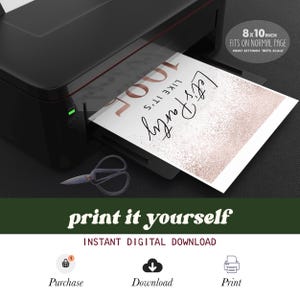May include: A black printer printing a white sheet with the text "Let's Party" in black script and "100" in rose gold. The sheet is 8x10 inches and fits on a normal page. Scissors are on the surface. The image also includes the text "print it yourself".