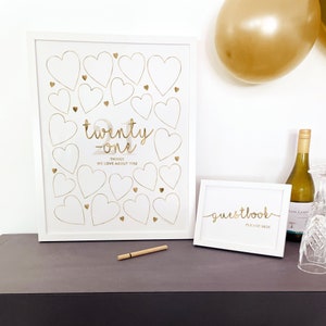 21st Birthday Sign made as a digital printable download for 21st Birthday Decoration to match Gold Party Supplies. Displayed on a black table in two white picture frames, with pen for Guests to write their heartfelt nostalgics messages for the 21 Year Old Woman.