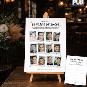 May include: A white sign on a wooden easel, celebrating "50 YEARS OF JACOB." The sign features twelve photos with numbers, and the text "How old was the birthday guy?" is on a separate sheet. The background is a pub.