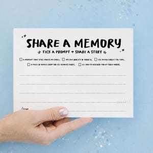 May include: A white rectangular card with black text that reads SHARE A MEMORY, TICK A PROMPT + SHARE A STORY, and lists five prompts with checkboxes, followed by four horizontal lines for writing and the word mom at the bottom left corner.