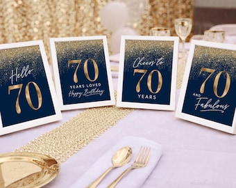 Könnte beinhalten: Vier gerahmte Schilder zum 70. Geburtstag in Marineblau und Gold. Jedes Schild hat einen weißen Rand und zeigt goldenen Text mit Sätzen wie "Hello 70", "70 Years Loved", "Cheers to 70 Years" und "70 and Fabulous".