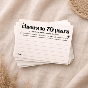 May include: A stack of off-white rectangular cards featuring the black text cheers to 70 years, tick a prompt + share a story, and five checkboxes with prompts including a moment that still makes me smile and a piece of advice from you.
