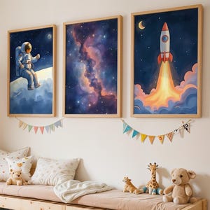 Könnte beinhalten: Ein Kinderzimmer mit einem großen Stofftier-Giraffen, einer Holzbank mit Stauraum und drei gerahmten Kunstdrucken zum Thema Weltraum. Die Drucke zeigen einen Astronauten, einen Nebel und eine Rakete. Kissen und Stofftiere vervollständigen das gemütliche Setup.
