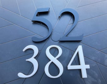 May include: Black and white house numbers. The numbers 52 are black and the numbers 384 are white.