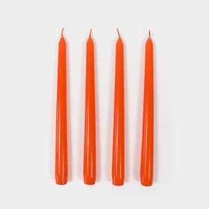 May include: Four orange taper candles on a white background.