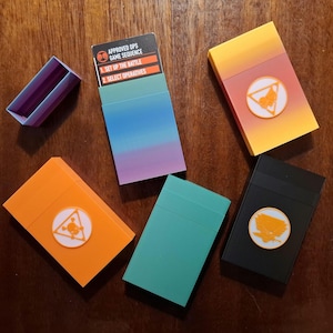 Grote opbergdoos voor goedgekeurde bewerkingen of datakaarten. Voor kaarten in hoesjes. Keuze van het factielogo op aanvraag. Frictiepasvorm. 30 mm x 74 mm x 125 mm.