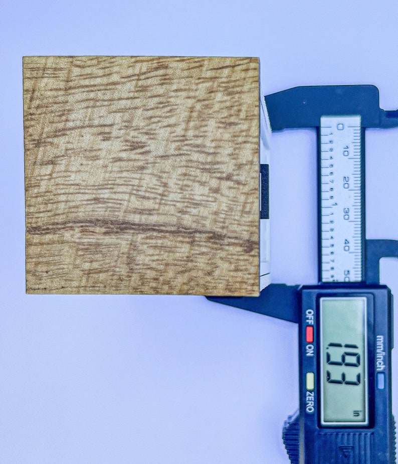 Puede incluir: Un bloque de madera que se mide con un calibre digital. El calibre muestra 1,93 pulgadas.