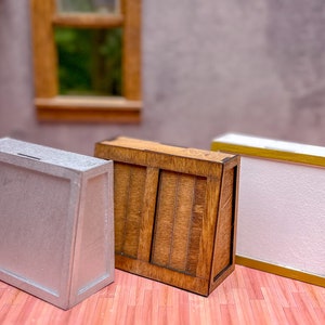 May include: Three miniature wooden boxes, one silver, one brown with wood grain, and one white with a gold trim.