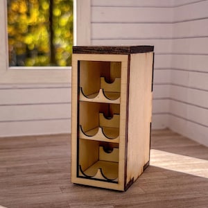 May include: A wooden wine rack with four shelves, each with two slots for holding wine bottles. The rack is made of light wood with a dark brown stain on the top and sides.