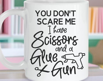 May include: White ceramic coffee mug with a black design that says "You don't scare me I have scissors and a glue gun".