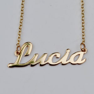 Könnte beinhalten: Goldkette mit dem Namen "Lucia" in Schreibschrift.