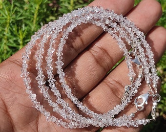 May include: A strand of multiple rows of clear, faceted, diamond beads strung on a silver chain with a silver clasp.