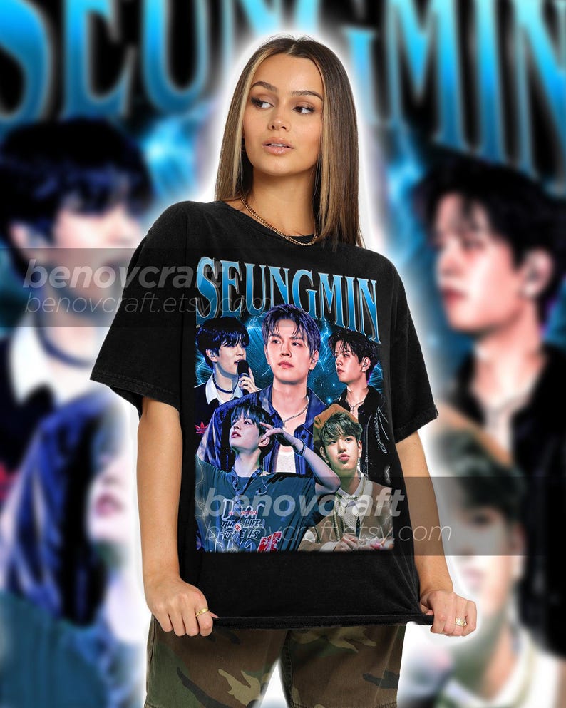 May include: Black t-shirt with a graphic print of a group of men with the word "SEUNGMIN" printed in blue letters.