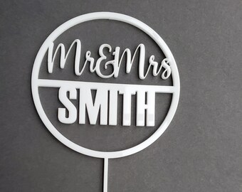 Mr and Mrs round acrylic cake topper with last name. Wedding cake topper