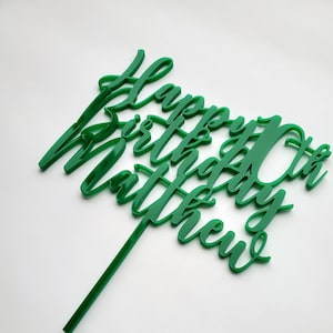 Könnte beinhalten: Grüner Acryl-Kuchentopper mit dem Text "Happy 10th Birthday Matthew".
