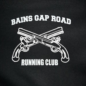 May include: Black and white graphic design of two crossed pistols with the text "Bains Gap Road Running Club" above them.
