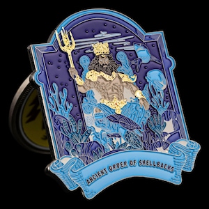 May include: A detailed, rectangular pin featuring a sea god with a golden crown and trident, surrounded by marine life. The pin is primarily blue and gold, with the text "ANCIENT ORDER OF SHELLBACKS" on a banner.