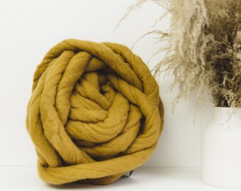 May include: A large ball of mustard yellow chunky yarn, perfect for knitting or crocheting a cozy blanket or throw.