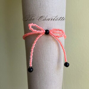 Coral orange bead stretch bracelet with black beading