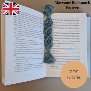 K&ouml;nnte beinhalten: T&uuml;rkis-farbener Makramee-Lesezeichen mit Rautenmuster und Quaste in einem Buch. Der Text "Macrame Bookmark Pattern" und "PDF Tutorial" sind sichtbar.