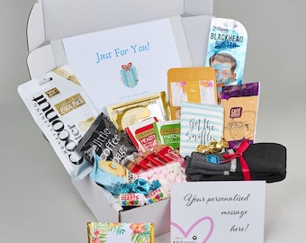May include: A white gift box filled with various items, including a face mask, socks, chocolate, tea bags, and candy. The box is labeled "Just For You!" and "Hug In A Box".