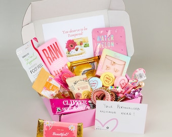 Pode incluir: Uma caixa de presente rosa cheia de itens de autocuidado. Inclui um peeling para os pés, barra de chocolate, máscara para os olhos, colar e outras guloseimas. A caixa tem cartões que dizem "You deserve to be Pampered!" e "Your personalised message here!"