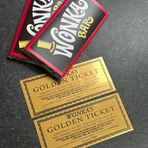 Pode incluir: Dois bilhetes dourados com o texto "Wonka's Golden Ticket" e instruções para apresentar o bilhete nos portões da fábrica. Os bilhetes estão em cima de duas barras de chocolate com o texto "Wonka Bar" impresso neles.