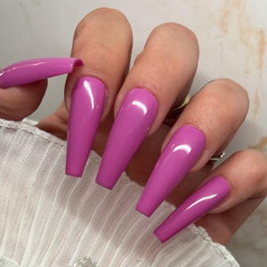 Könnte beinhalten: Lange, rosafarbene, sargförmige Press-on-Nägel mit glänzendem Finish.