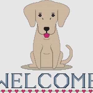 May include: A cross-stitch design featuring a tan-colored dog with a pink tongue, sitting upright. Below the dog, the word "WELCOME" is stitched in blue, with a row of pink hearts and green stems beneath the text. The design is on a white background.