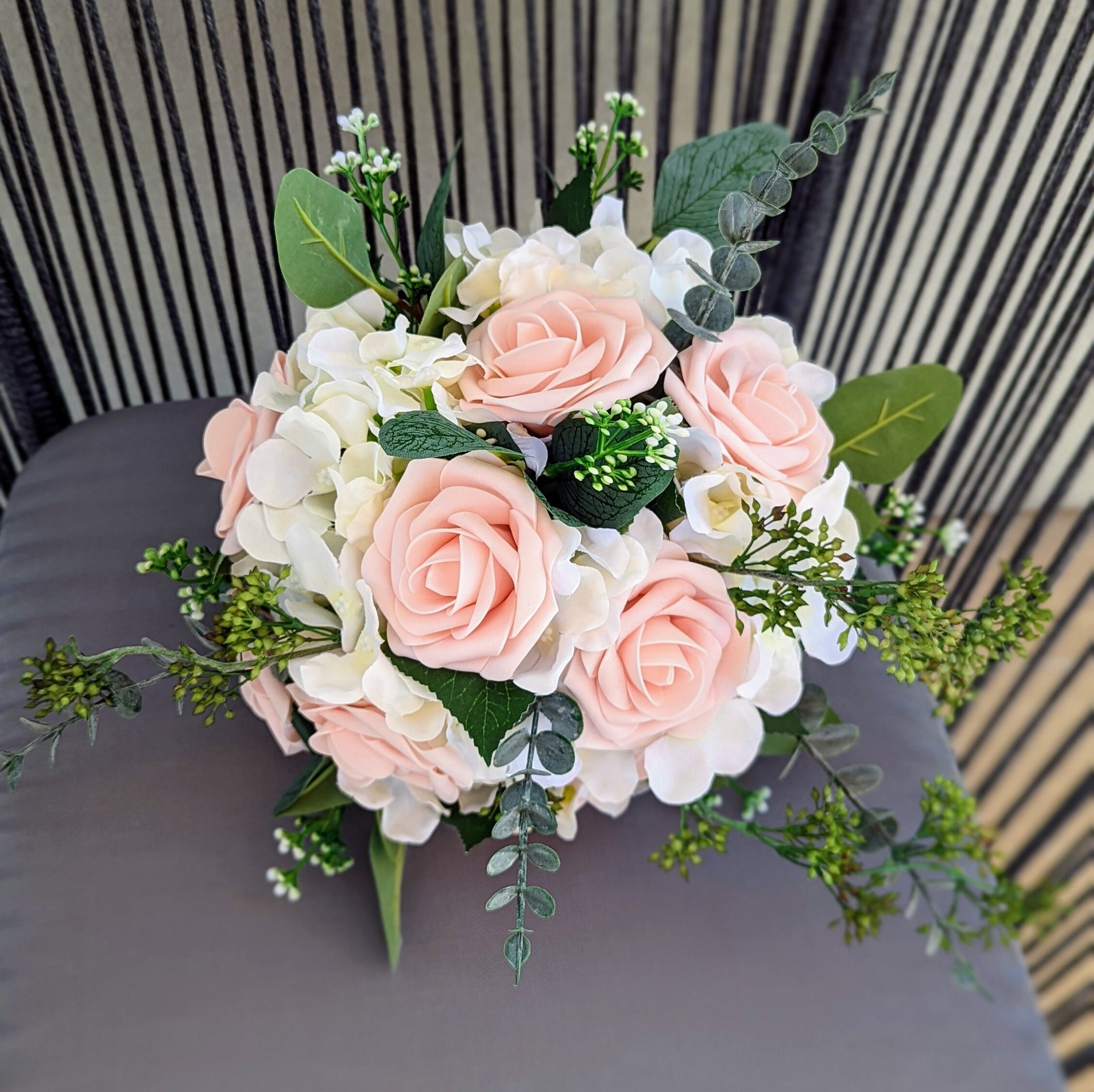 Wedding bouquet of white hydrangea and pink roses with diamond pins.  Doristhefloristt.com