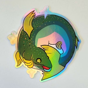 Può includere: Un adesivo olografico raffigurante un pesce stilizzato nei toni del verde, giallo e blu. Il pesce è arricciato, con bocca rossa e occhio giallo. L'adesivo ha un effetto brillante e iridescente e dettagli a forma di stella.