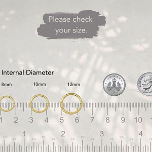 May include: Three gold-colored hoop rings with textured surfaces, labeled with internal diameters of 8mm, 10mm, and 12mm. A ruler shows measurements in inches and centimeters. A five-pence coin and a dime are included for scale. Text reads: Please check your size.