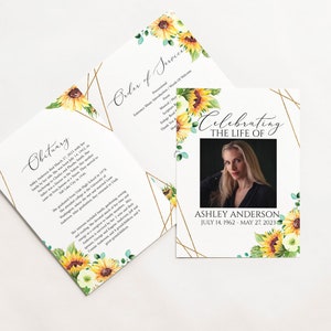 May include: A white memorial card with a gold geometric frame and sunflower accents. The card features a photo of a woman and the text "Celebrating the Life of Ashley Anderson July 14, 1962 - May 27, 2023".