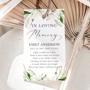 Könnte beinhalten: Weiße Blumen-Gedenkkarte mit dem Text "In Loving Memory Emily Anderson July 14, 1967 - May 22, 2023" und einem Gedicht über das Gedenken an jemanden, der verstorben ist.